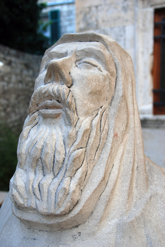 statue of an old man praying